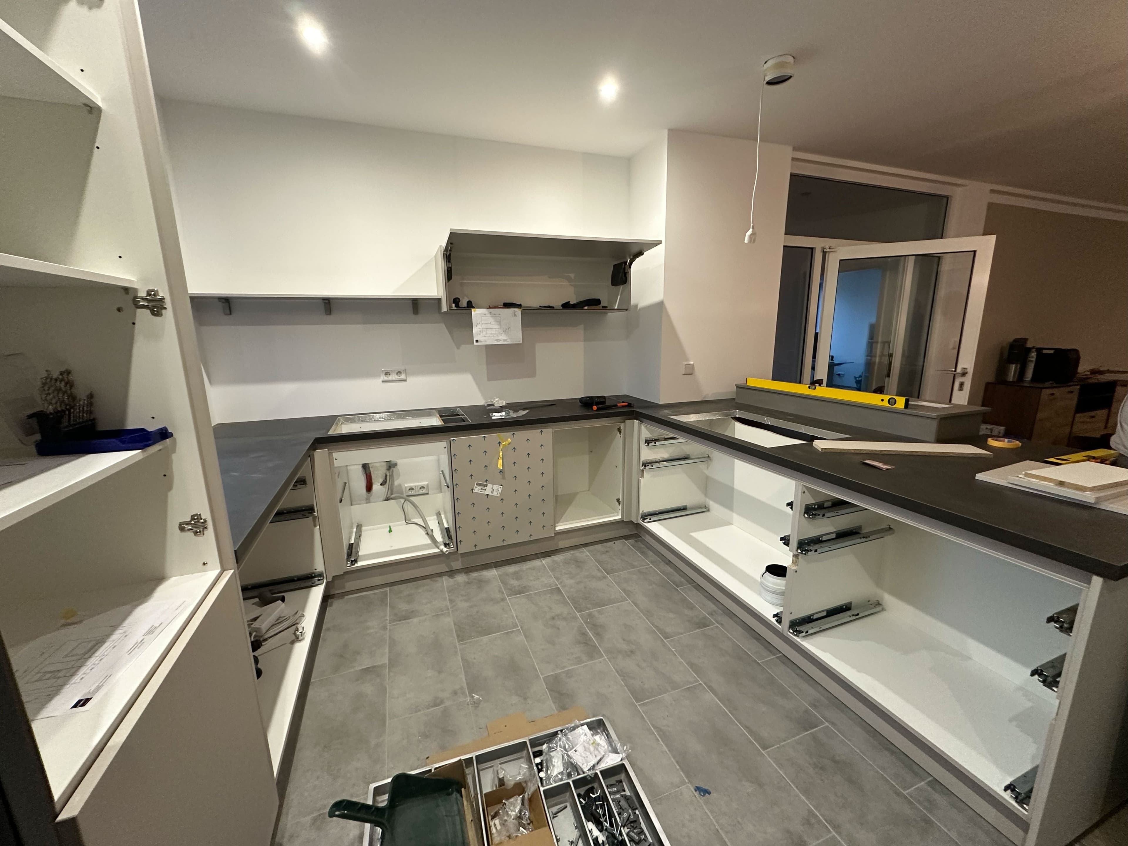 Professioneller Küchenaufbau einer L-Küche während der Montage mit fachgerechter Installation der Arbeitsplatte durch einen Experten in Erkelenz.